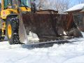 A Superior Asphalt team member clearing snow using a front end loader